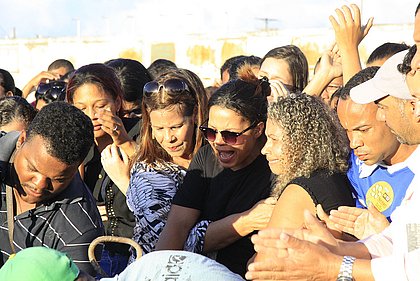 No enterro da filha, Ana Conceição Alves (de óculos escuros) precisou ser amparada por amigos e familiares