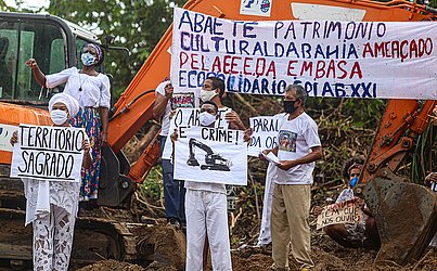 Manifestantes exibiam cartazes pedindo a paralisação da obra, respeito à cultura local e ao povo de matriz africana, que tem a lagoa um local sagrado.