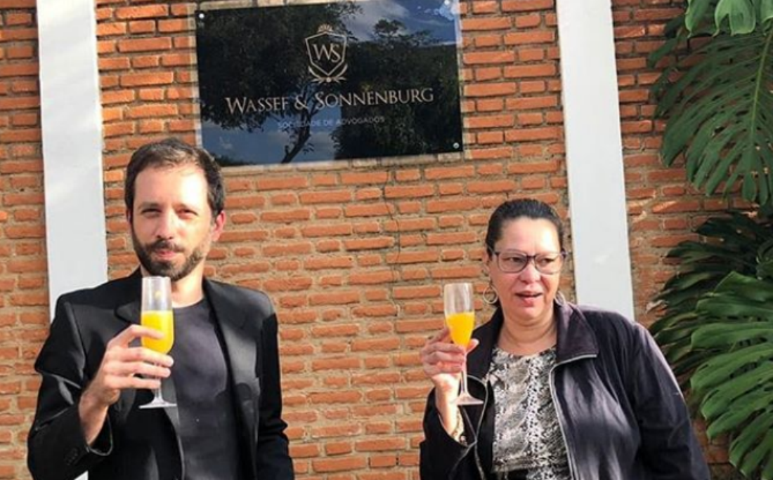 Bruno Maia e Heloísa de Carvalho posam em frente a casa de Wassef em Atibaia, tomando suco de laranja